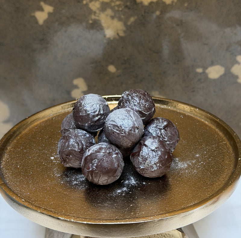 Chocolate truffles on a gold ceramic plate with a textured background